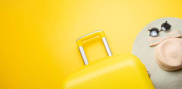 istock The flat lay a yellow suitcase with accessories for relaxing on a yellow background. concept of travel, rest and relaxation. Banner for advertising 1125954527