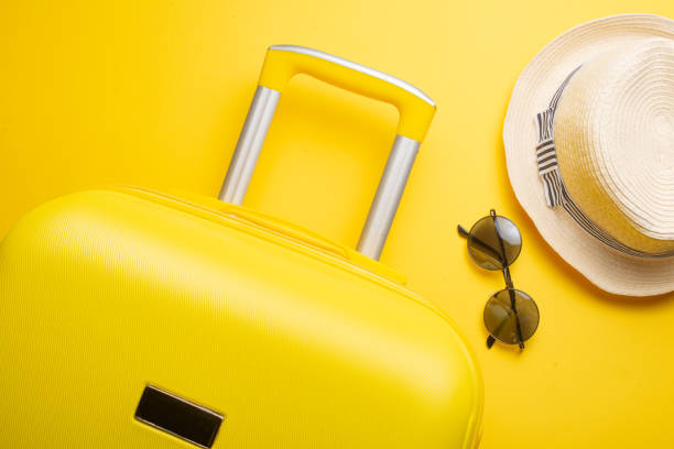 istock The flat lay a yellow suitcase with accessories for relaxing on a yellow background. concept of travel, rest and relaxation 1125957911