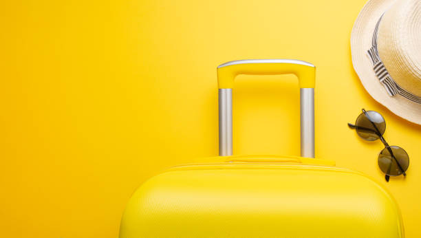 istock The flat lay a yellow suitcase with accessories for relaxing on a yellow background. concept of travel, rest and relaxation. Banner for advertising 1125958152