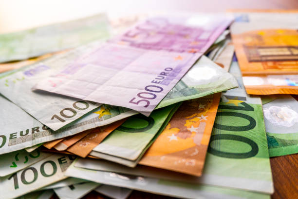 istock Euro banknotes in salary envelope. Open envelope with money banknotes on table. White envelope with Euro bills. Closeup on Envelope full of euro cash. Euro money currency. International monetary 1125965871