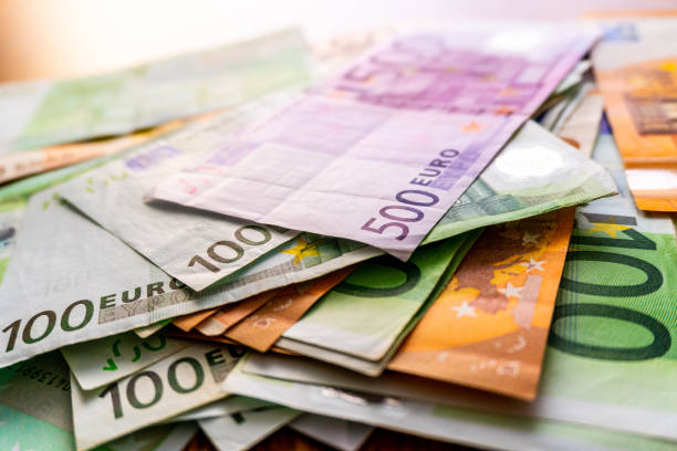 istock Euro banknotes in salary envelope. Open envelope with money banknotes on table. White envelope with Euro bills. Closeup on Envelope full of euro cash. Euro money currency. International monetary 1125965937