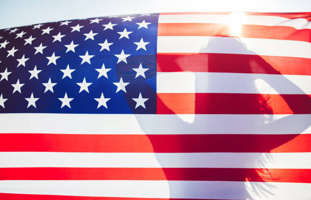 istock Female silhouette behind USA flag 1125968665