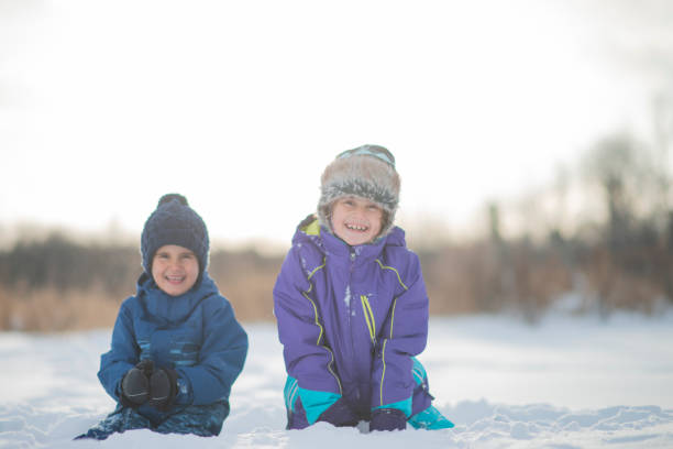 istock Kids Sitting In Snow 1125969264