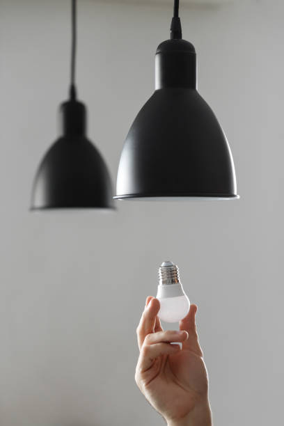 istock Changing the bulb for led bulb in floor lamp in black colour. On light gray background. 1125972065