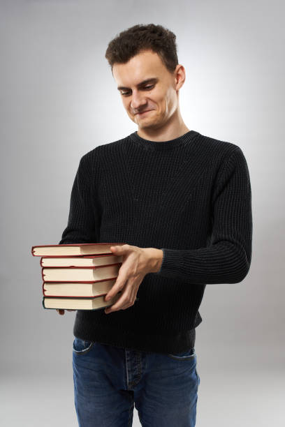 istock Unhappy student with a stack of books 1125973658