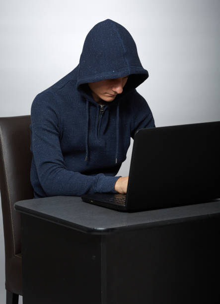 istock Hooded hacker at his laptop 1125974049