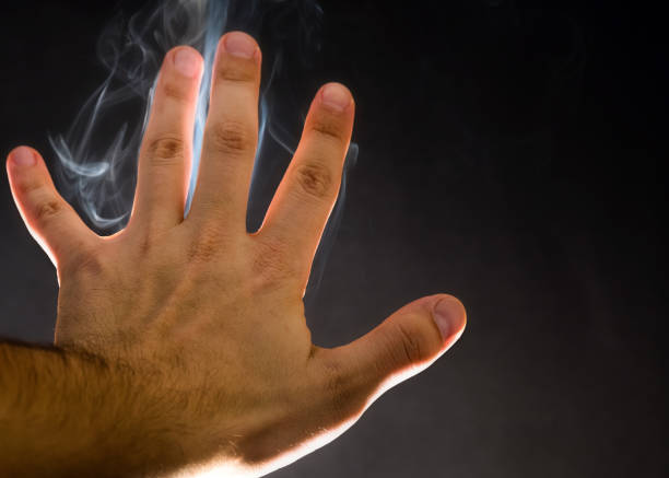 Close up of woman's hand holding lit cigarette