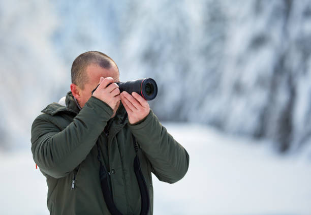 istock Man with camera outdoor in the snow 1125976491