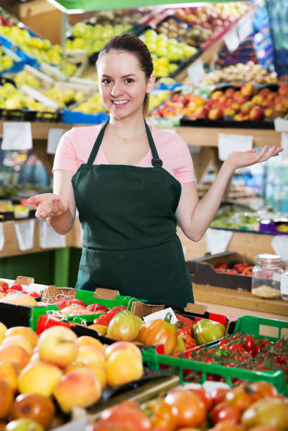 istock Female grocery worker welcoming to vegetable store 1125978936