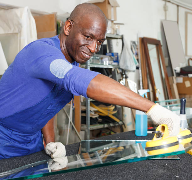 istock attentive African American glazier choosing glass for cutting in workshop 1125980266