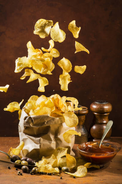 meal with ketchup and fries paper bag with fries and spices on a rustic wooden board alimentazione non salutare stock pictures, royalty-free photos & images