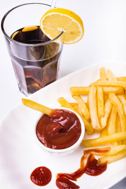 meal with ketchup and fries meal with a plate of fries, tomato sauce and drink alimentazione non salutare stock pictures, royalty-free photos & images