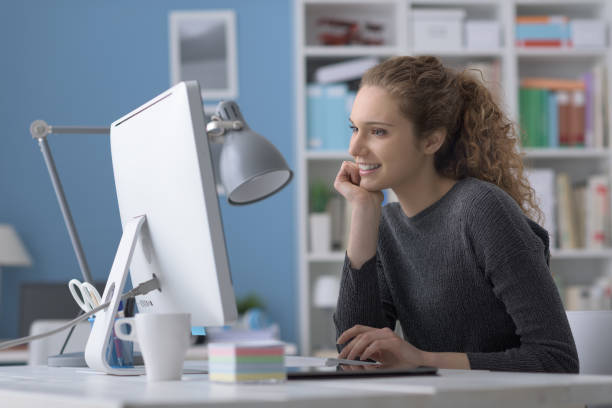 istock Young smiling beautiful woman using a computer in the office and connecting online, she is studying and working 1125981875