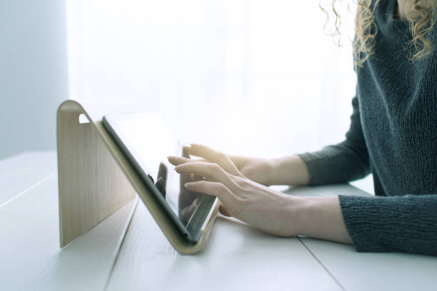 istock Woman using apps on a digital tablet and websurfing, hands close up 1125982232