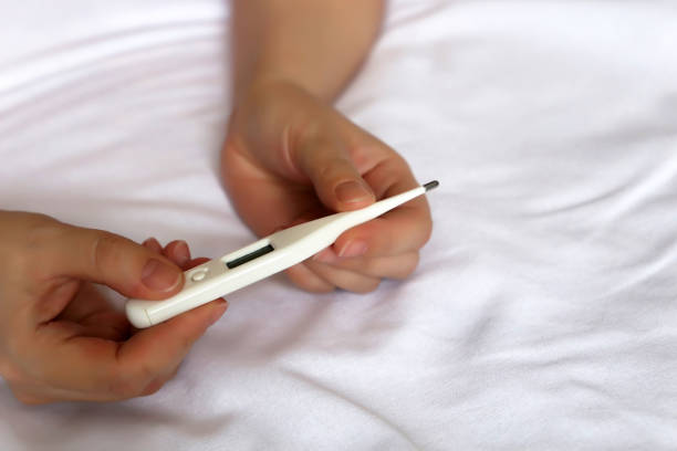 istock Digital thermometer in female hands close up on the bed 1125982265