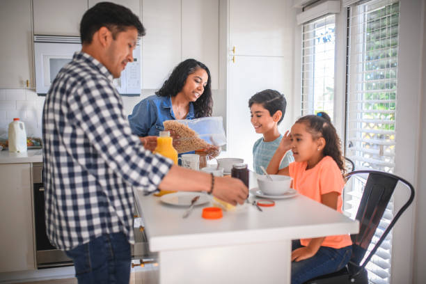 istock Happy family of four having breakfast in kitchen 1125983264