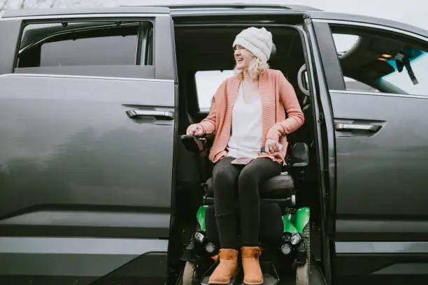 Photo of Cheerful Young Woman In Wheelchair Entering Vehicle