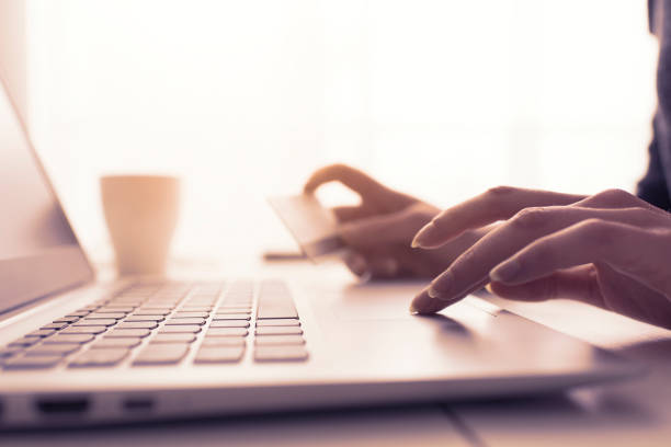 istock Woman doing online shopping using her laptop and a credit card, hands close up, e-commerce and online banking concept 1125983385