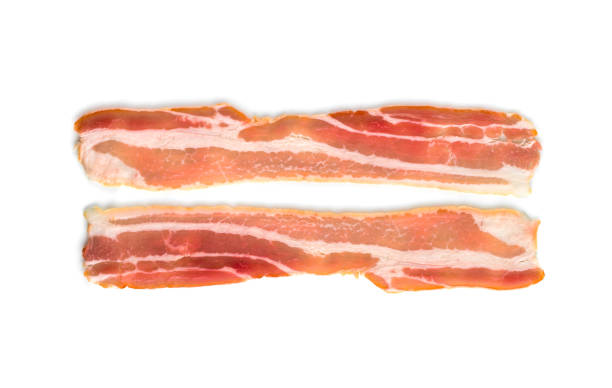 A slice of bacon on a white background. Two raw bacon closeup on a white background. A slice of bacon on a white background. Two raw bacon closeup on a white background. twisted bacon stock pictures, royalty-free photos & images