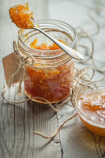 candied fruit jelly. orange marmalade. Jar of orange jam on wooden background