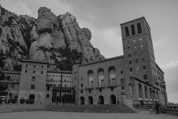 A black and white picture of the Santa Maria de Montserrat Abbey's facade and square.