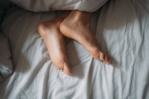 istock Close-up woman feet alone in white bed 1125988418