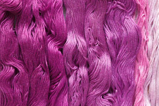 istock Threads of purple shades on the white canvas. 1125988558