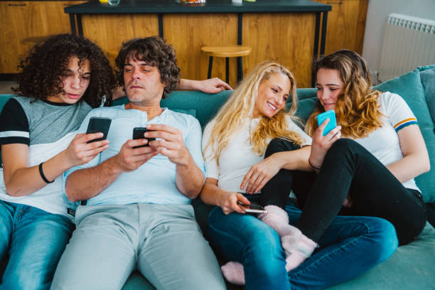 istock Family using smart phones  while relaxing on the sofa 1125990756