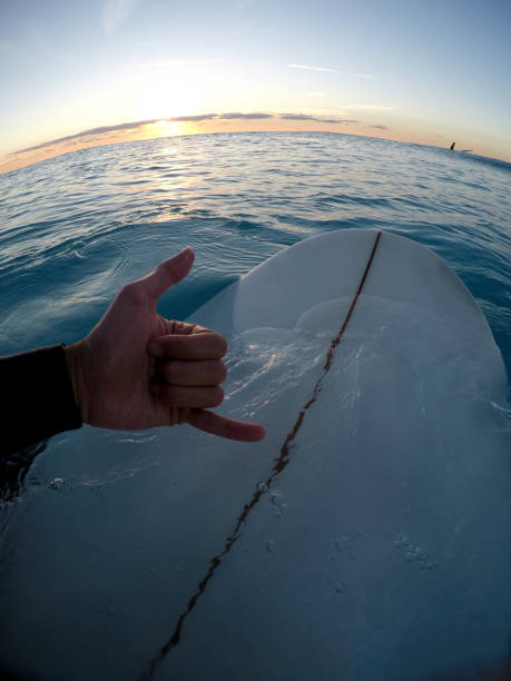 istock Man making a shaka sign on surfboard 1125992505