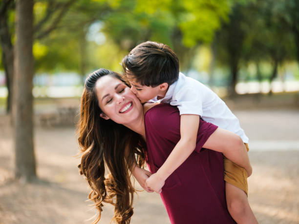 istock Cheerful latin mother carrying son on back and smiling 1125992711