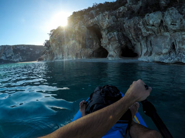istock Stand up paddling towards caves on the beach 1125993216