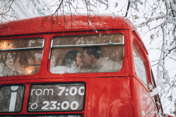 Loving young couple kissing in the red bus, enjoy each other stock photo