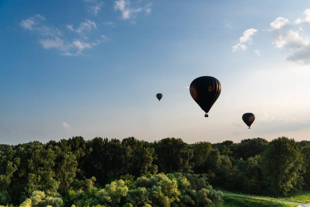 istock Three hot air balloons flying over woods 1125994536
