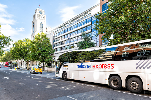 London, UK - September 15, 2018: National Express shuttle bus parked white sign text transport service on street road by Victoria Coach Station exterior building