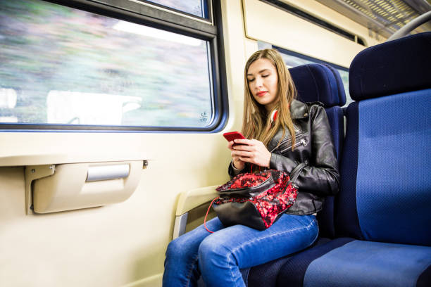 istock Young woman using phone in train 1125996173