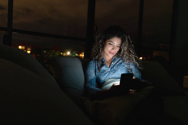 istock Woman at home using app on her cell phone while relaxing at nighttime 1125999598