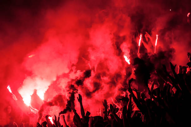 футбольные болельщики зажгли свет, факелы и дымовые шашки - sport crowd fan stadium стоковые фото и изображения