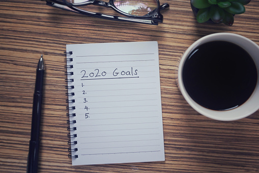 2020 Goals’ written on a notebook. Vintage styled background.