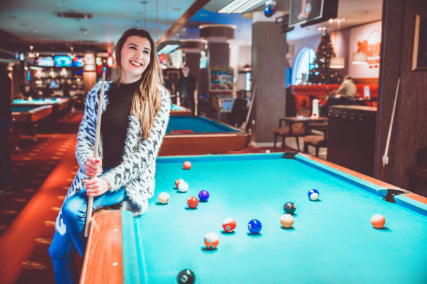 istock Woman sitting on billiard table 1126003390