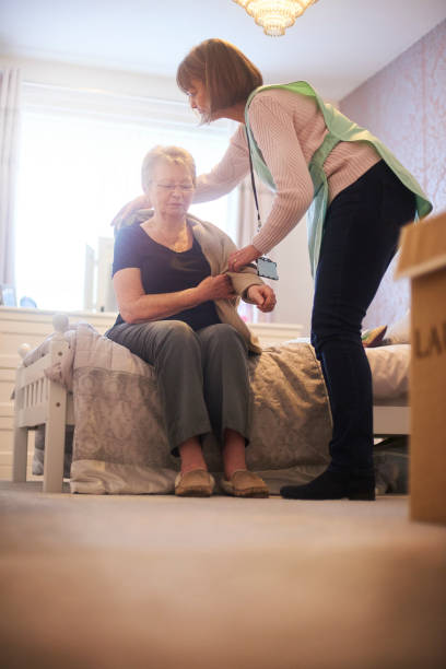 istock Senior woman assisted with getting dressed 1126004164