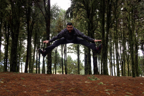 istock Young man jumps in forest with fog on background 1126007755