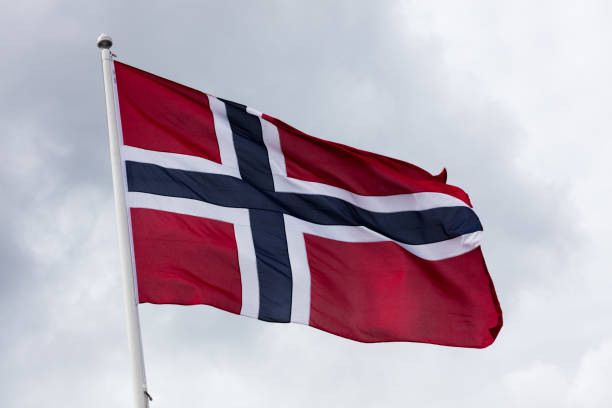 istock Cloudy sky and a flag of Norway 1126010251