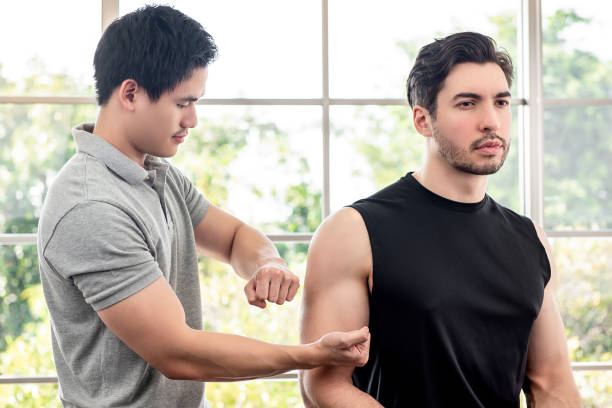 terapeuta dando masaje a paciente masculino de atleta por golpeando y golpeando - massaging men swedish culture male fotografías e imágenes de stock