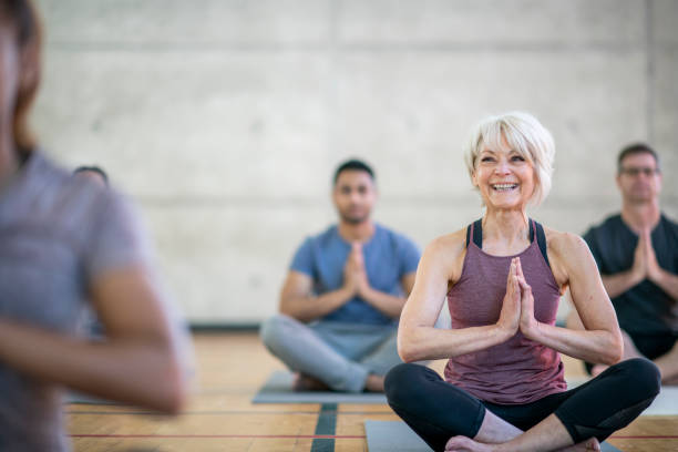 istock Smiling senior woman holding prayer pose 1126011118
