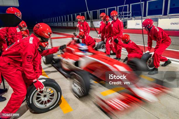 Red Formula Race Car Leaving The Pit Stop Stock Photo - Download Image Now - Pit Stop, Teamwork, Racecar