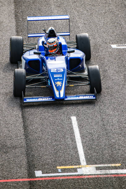 istock Open-wheel race car driver waving to his fans 1126024076