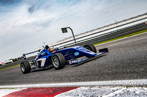 Blue single-seater formula race car on the track.