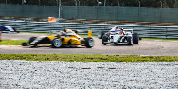 istock Open-wheel race cars going around the bend 1126024192