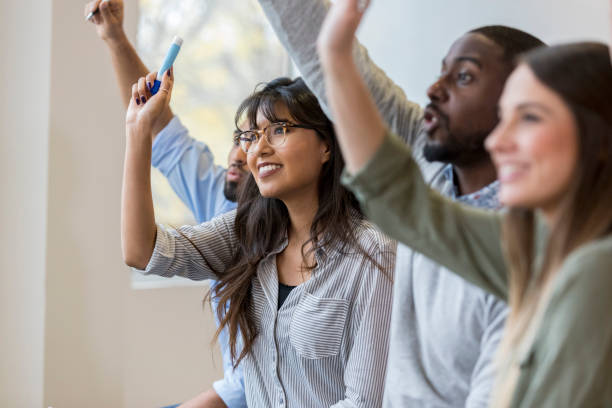 istock Group of business people raising hands during training class 1126024418
