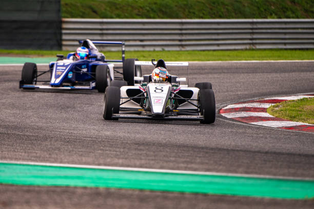 istock Two formula race cars making a turn 1126025438